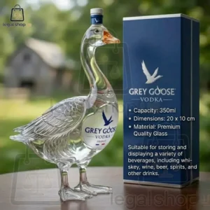 A decorative glass Grey Goose vodka bottle in the shape of a goose beside its packaging box.
