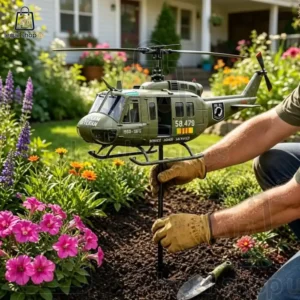 Vietnam Veteran Memorial Huey Helicopter Wind Spinner A person planting a military helicopter garden stake in a flower bed.