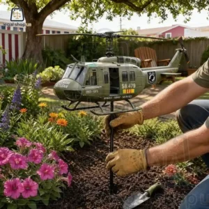 Vietnam Veteran Memorial Huey Helicopter Wind Spinner A person placing a military helicopter garden stake in a flower bed.