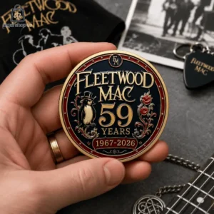 A hand holding a collectible Fleetwood Mac 59th anniversary commemorative coin.