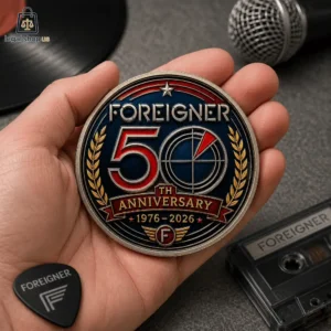 Commemorative Foreigner 50th Anniversary circular metal coin held in hand