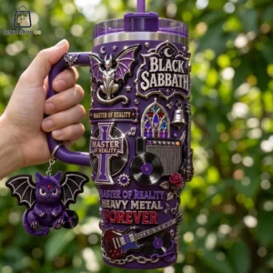 A hand holding a purple insulated tumbler featuring Black Sabbath Master of Reality theme with 3D metal accents and a bat plush keychain.