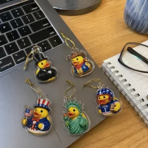 All-American Road Trip Ducks Advent Calendar 2026 Five decorative acrylic rubber duck ornaments featuring American-themed costumes displayed on a laptop