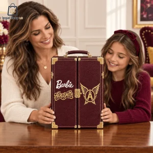 A woman and a young girl looking at a decorative Barbie and Aerosmith branded travel trunk.