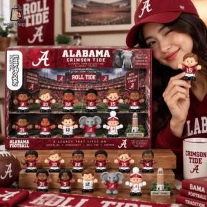 Woman holding an Alabama Crimson Tide Little People collector set featuring miniature football player figures.