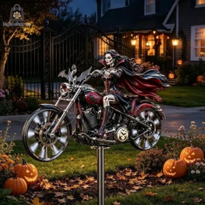 Vampire woman figurine riding a motorcycle lawn ornament with Halloween pumpkins.