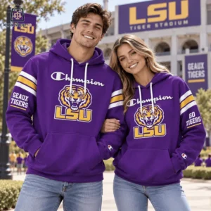 A couple wearing matching purple and gold LSU Champion hoodies outside Tiger Stadium.