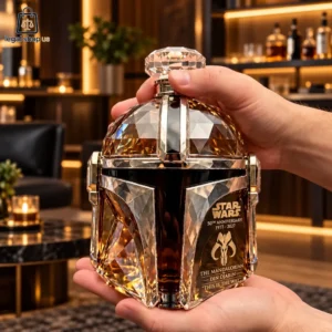 A hand holding a Star Wars The Mandalorian 50th Anniversary crystal whiskey decanter.