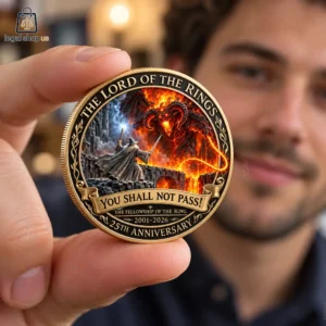 Person holding a golden Lord of the Rings 25th anniversary commemorative coin.